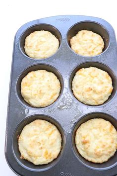 a muffin tin filled with cooked biscuits