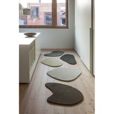 four rugs on the floor in front of a window