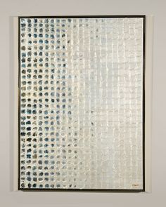 an abstract painting with white and blue dots on the bottom, in a black frame