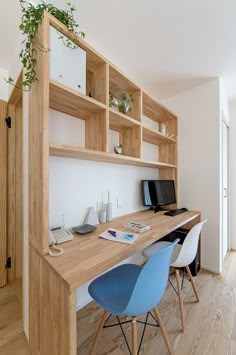 a desk with two chairs and a computer monitor on top of it in front of a bookshelf