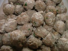 a white bowl filled with meatballs on top of a table