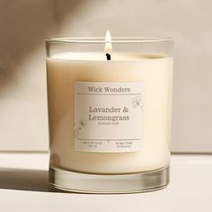 a candle with a label on it sitting next to a white wall and window sill