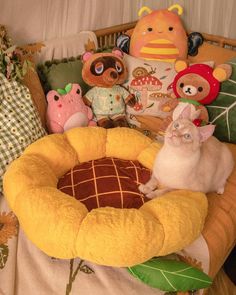 two cats are sitting in a bed with stuffed animals