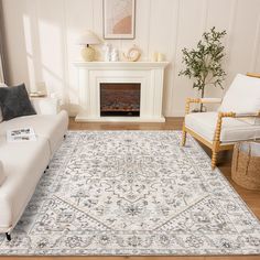 a living room with white furniture and a rug on the floor in front of a fireplace