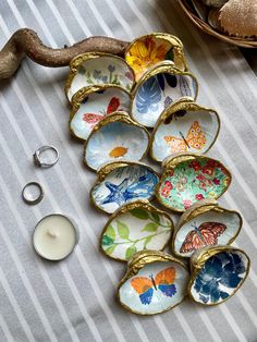 a table topped with lots of different types of dishes next to a candle and ring