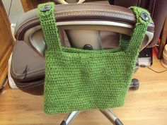 a green bag sitting on top of a chair