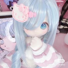 a close up of a doll with blue hair