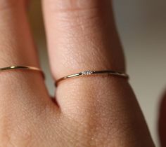 a woman's hand with a gold ring on her finger and diamond in the middle