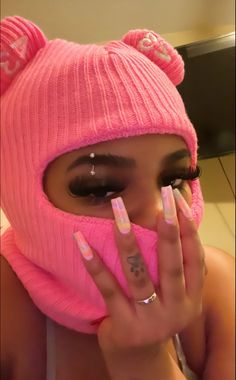 a woman wearing a pink hat and matching nails