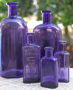 purple glass bottles sitting on top of a table