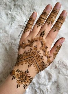 a woman's hand with henna tattoos on it