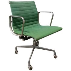 a green office chair sitting on top of a metal base