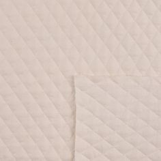 two pieces of white quilted material are laying on top of each other in the same pattern