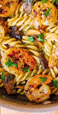 pasta with shrimp, mushrooms and parsley in a pan