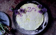 a round cake with purple flowers on top