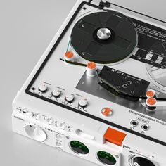 a turntable with two discs on top of it and an orange tape recorder next to it