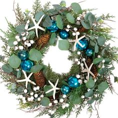 a christmas wreath with starfishs, holly and blue baubles on it