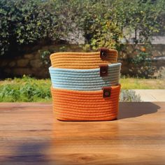 three woven baskets sitting on top of a wooden table