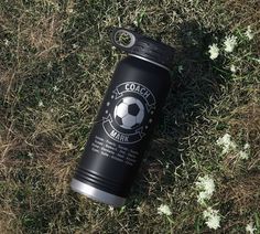 a water bottle laying on the ground in grass