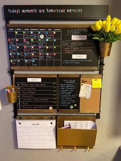 a bulletin board mounted to the side of a wall next to a potted plant