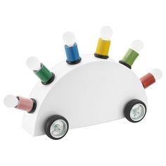 a white toy car with colorful thread spools on it