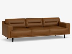 a brown leather couch sitting on top of a white floor