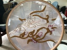 a glass plate with embroidery on it in the shape of a horse's head