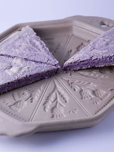 two pieces of purple cake sitting on top of a plate