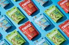 several packets of twizz are lined up on a blue surface with red and green packaging