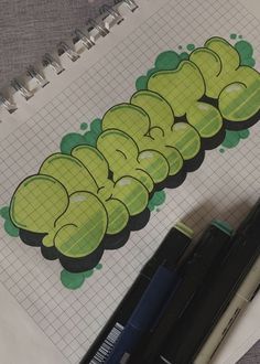 an open notebook with the word caterpillar written in green on it next to a pen