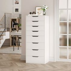 a white chest of drawers sitting next to a stair case