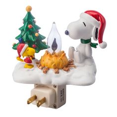 a snoopy christmas scene with a dog and a campfire