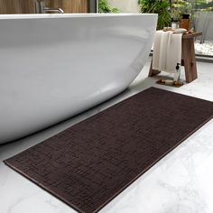 a bathtub sitting next to a white tub in a room with marble flooring