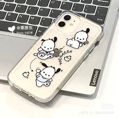 an iphone case with hello kitty stickers on it sitting in front of a laptop