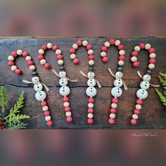 the word happy spelled out with snowmen and christmas decorations on a wood plank background