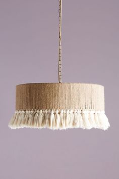 a light fixture with fringes hanging from it's side on a purple wall