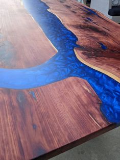 a wooden table with blue water painted on the top and wood grain inlays