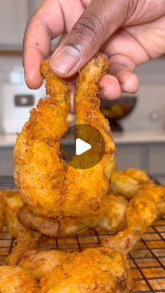 a person holding up some fried food on a rack