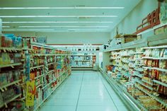 an aisle in a grocery store filled with lots of shelves and food on the floor