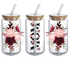 three mason jars with floral designs and straw lids