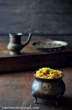 a bowl filled with food sitting on top of a table next to a tea pot