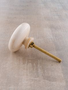 a screw is attached to the side of a door knob on a white tablecloth