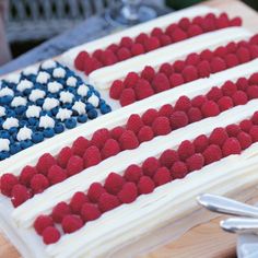 an american flag cake with red, white and blue icing on a cutting board