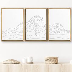 three framed art pieces on a wall above a dresser