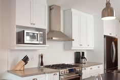 a kitchen with white cabinets and stainless steel appliances