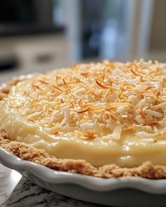 a pie topped with coconut flakes on top of a table