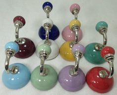 several different colored glass knobs with metal handles on each one side and an oval handle on the other