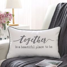 a pillow that says together is a beautiful place to be on a chair with flowers in the background