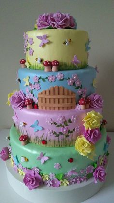 a multi layer cake decorated with flowers, mushrooms and other things in pastel colors