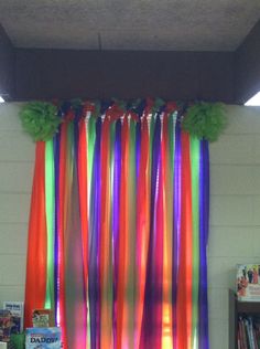 colorful streamers hanging from the ceiling in front of a book shelf and bookshelf